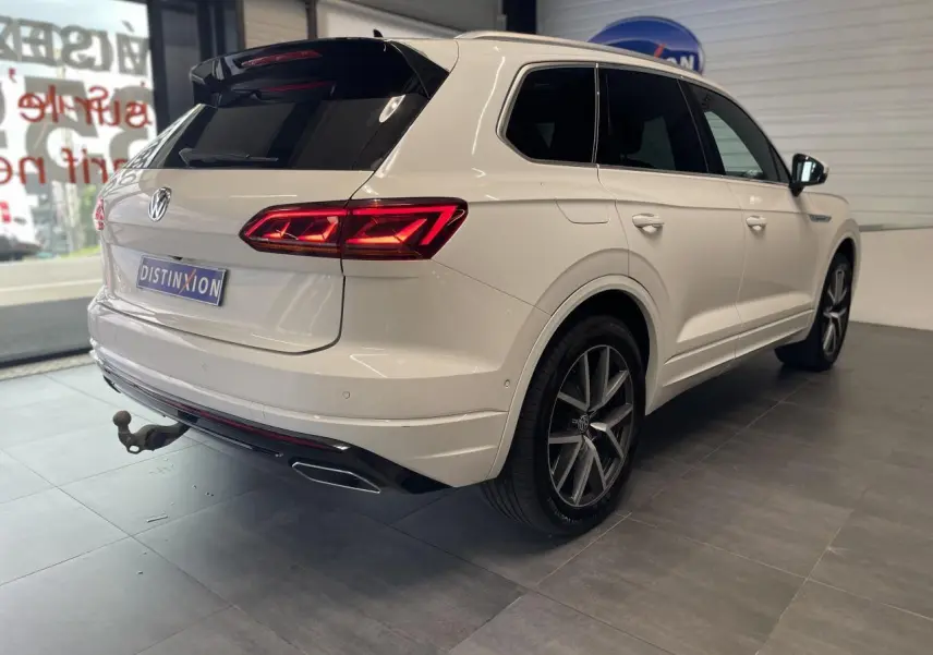 Vue 3/4 arrière droit du Volkswagen Touareg blanc avec jantes alliage 20 pouces et feux arrière LED allumés