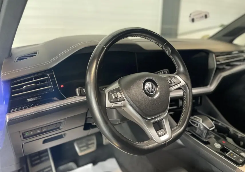 Volant cuir noir avec surpiqûres blanches de Volkswagen Touareg 2019, vue intérieure côté conducteur.