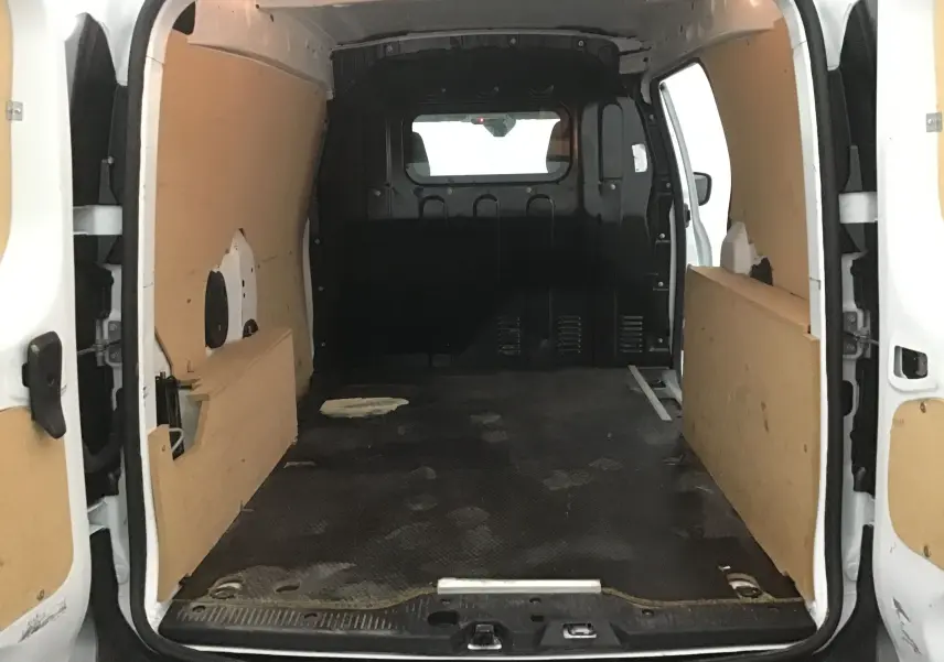Vue intérieure arrière du Renault Express Van blanc 2023, montrant l'espace de chargement avec parois en bois et sol noir antidérapant.
