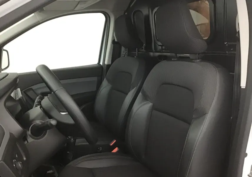 Vue intérieure côté conducteur du Renault Express Van 2023 blanc, sièges noirs et cloison séparatrice visible.