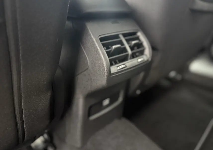 Détail des aérateurs arrière et prise USB dans l’habitacle sombre d’une Citroën C4 Hybrid 145 blanche.