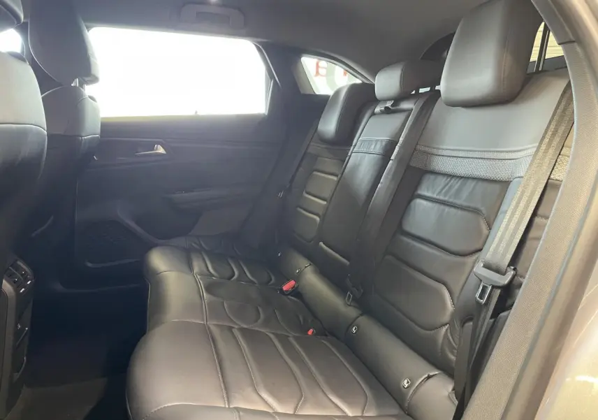 Vue intérieure montrant les sièges arrière en cuir noir du Citroën C5 X 2024, côté droit, avec ceinture de sécurité visible.