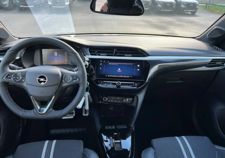 Vue intérieure frontale du poste de conduite de l’Opel Corsa Hybrid gris kristall avec écran tactile 10 pouces et volant multifonctions cuir.