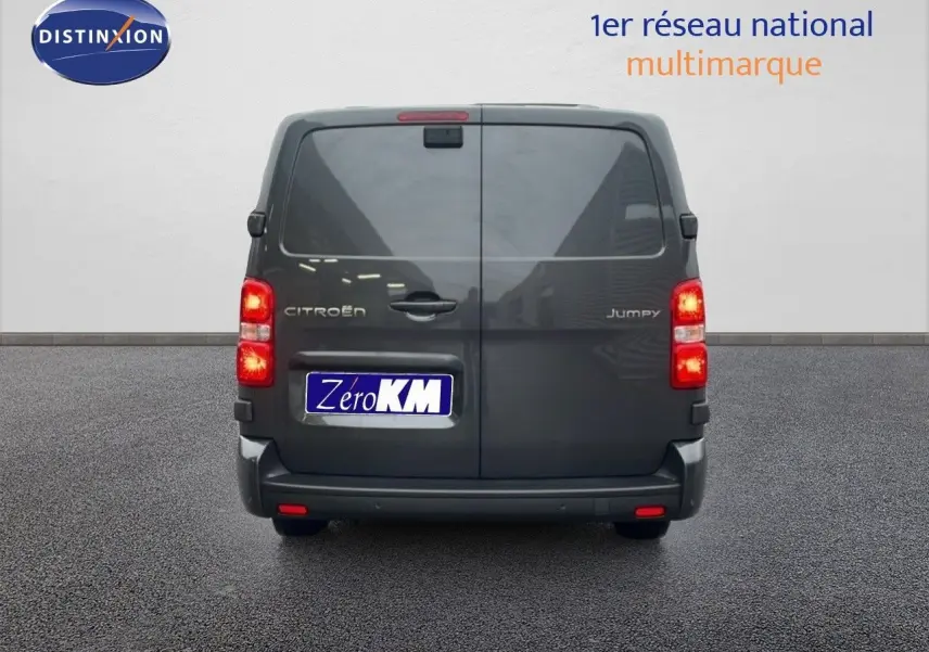 Vue arrière du Citroën Jumpy Cabine Approfondie gris titane métal avec feux allumés sur sol goudronné.