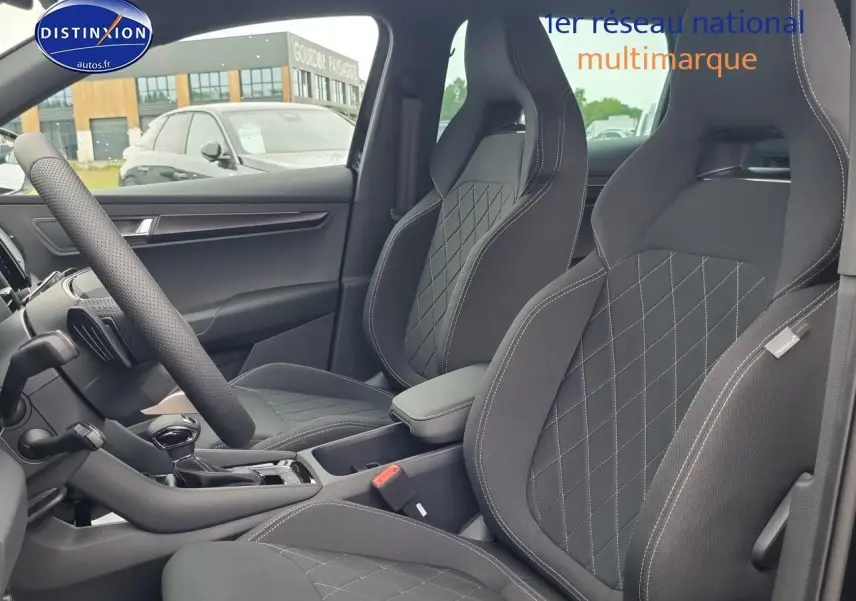 Intérieur du Skoda Karoq noir 2025, vue côté gauche sur sièges sport avec surpiqûres et accoudoir central.