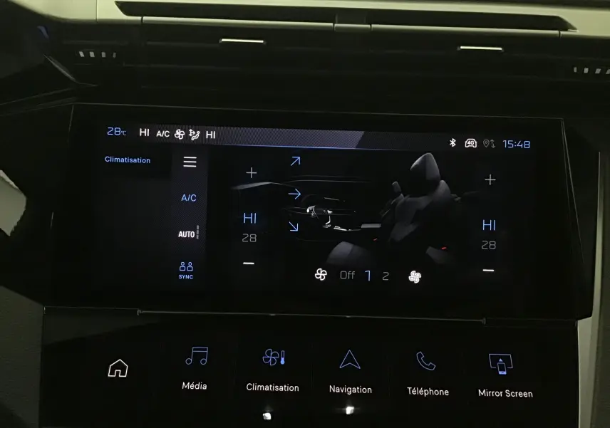 Écran tactile intérieur de la Peugeot 308 2025 gris Artense montrant les réglages de climatisation et fonctions multimédia.