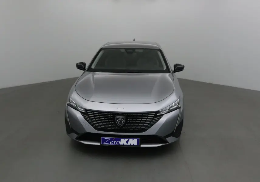 Peugeot 308 gris Artense vue de face, mettant en valeur la calandre noire et les phares LED fins.