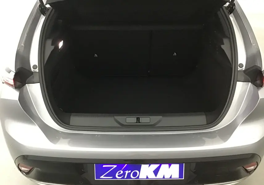 Coffre ouvert vu de l'arrière d'une Peugeot 308 2025 gris Artense, montrant l'espace de chargement vide.