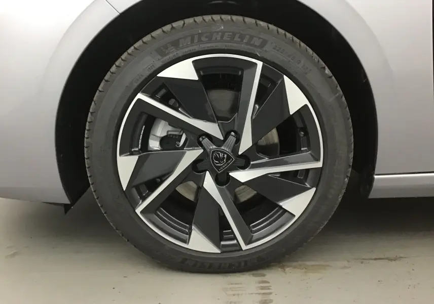Gros plan sur la roue avant gauche gris Artense d'une Peugeot 308 2025 avec jante alliage noire et argentée au design moderne.