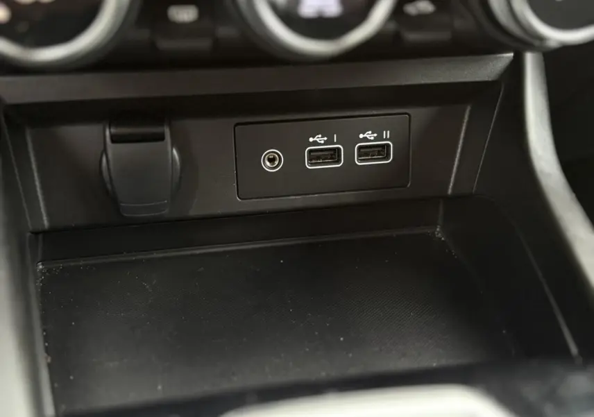 Vue rapprochée de la console centrale noire avec ports USB et prise jack du Renault Arkana TCE 140 EDC MHEV Evolution.
