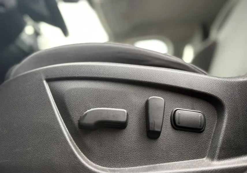 Gros plan sur les commandes électriques du siège conducteur d’un Renault Arkana 2025, intérieur noir.