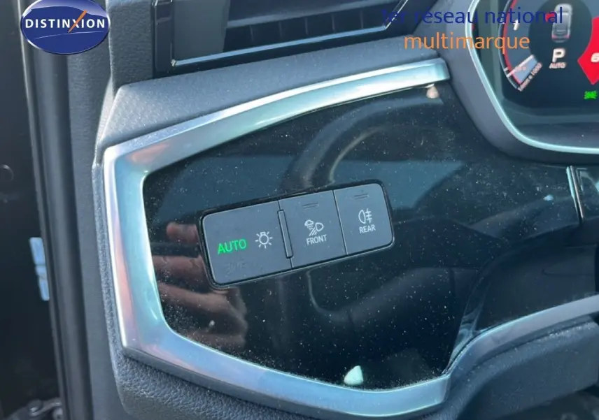 Gros plan sur les commandes d'éclairage intérieures d'un Audi Q3 Sportback noir, avec bouton auto allumé.