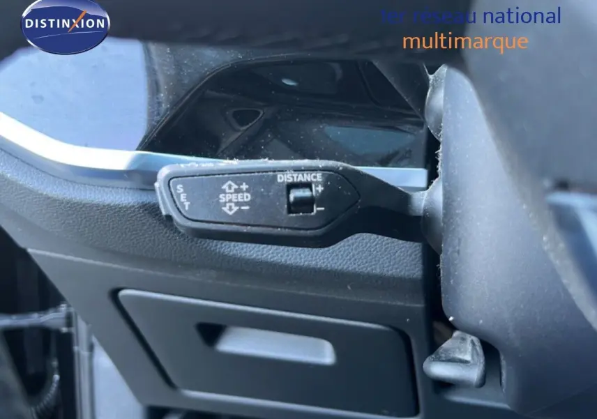 Gros plan sur la commande de régulateur de vitesse d’un Audi Q3 Sportback noir, côté gauche du volant.