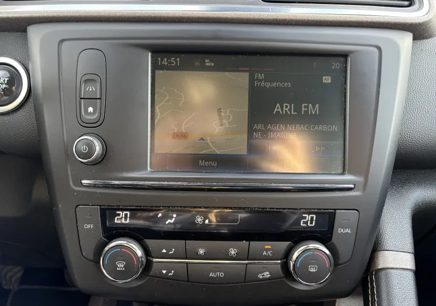 Vue rapprochée du tableau de bord du Renault Kadjar blanc 2015, avec écran tactile et commandes de climatisation.