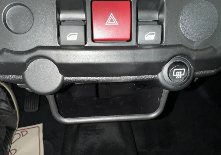 Détail du tableau de bord avec boutons de commande de vitres et bouton rouge de warning sur Aixam Ambition E City Pack 2026.