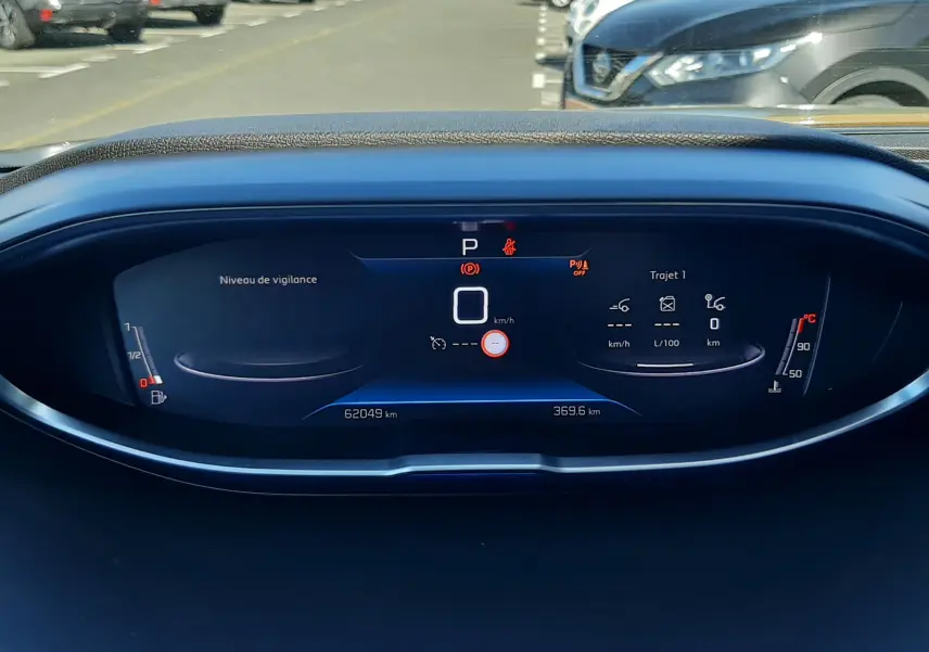 Vue rapprochée du tableau de bord numérique du Peugeot 3008 gris platinium, affichant la vitesse et les alertes.