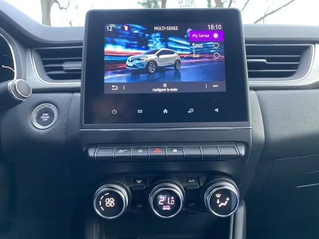 Vue rapprochée de l’écran tactile central du Renault Captur blanc nacré avec toit noir, affichant les modes de conduite Multi-Sense.