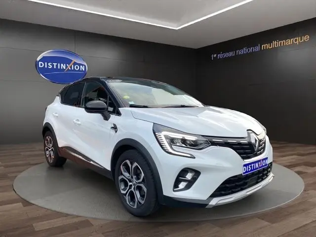 Renault Captur DCI 115 EDC Intens blanc nacré avec toit noir, vue 3/4 avant droit en showroom intérieur.