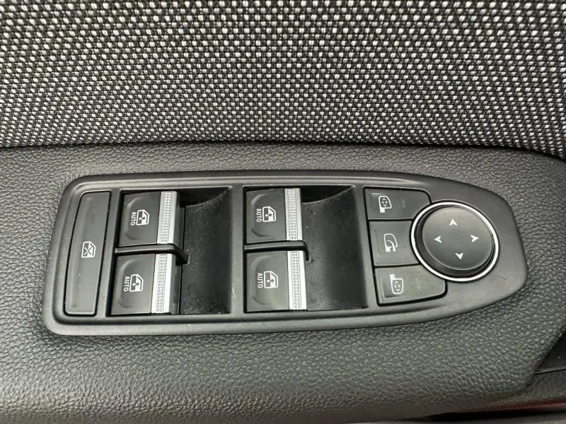 Gros plan sur les commandes de lève-vitres et rétroviseurs côté conducteur du Renault Captur 2025, finition Techno.