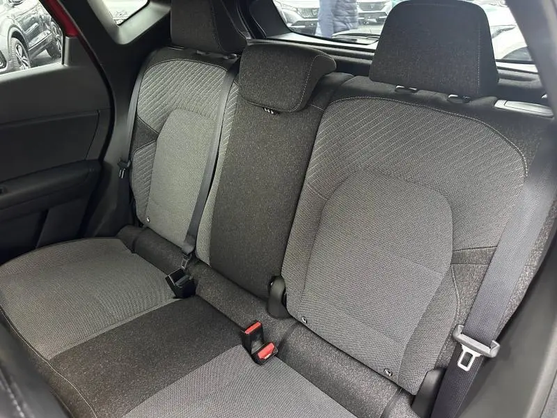 Vue intérieure arrière du Renault Captur 2025, sièges gris foncé avec ceinture de sécurité visible côté droit.