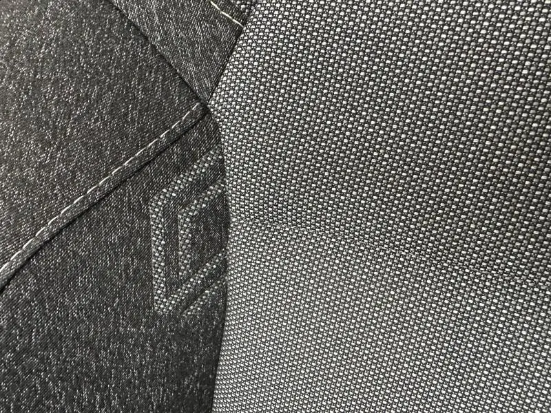Détail du tissu gris et noir avec surpiqûres et logo "CAPTUR" brodé sur le siège avant du Renault Captur 2025.