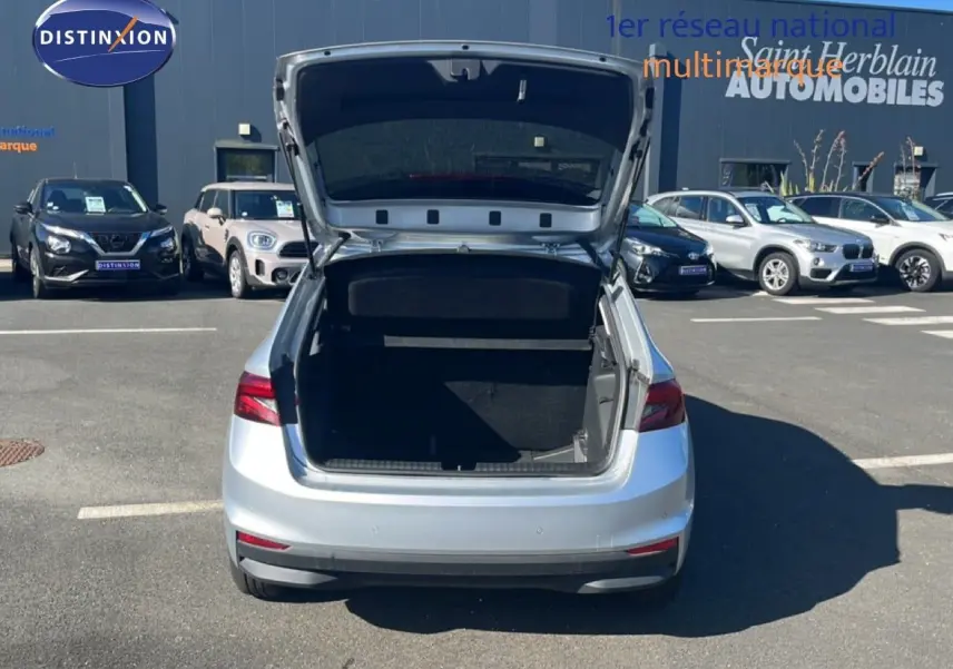 Vue arrière d'une Skoda Fabia 2025 Reflex Silver Metal avec coffre ouvert sur un parking extérieur.