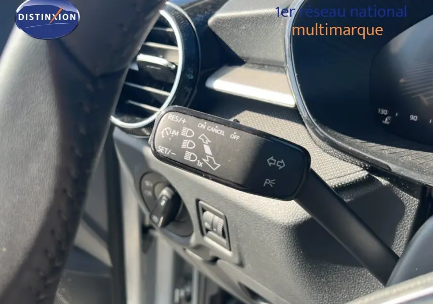 Gros plan sur la commande de régulateur de vitesse à gauche du volant d'une Skoda Fabia Reflex Silver 2025.
