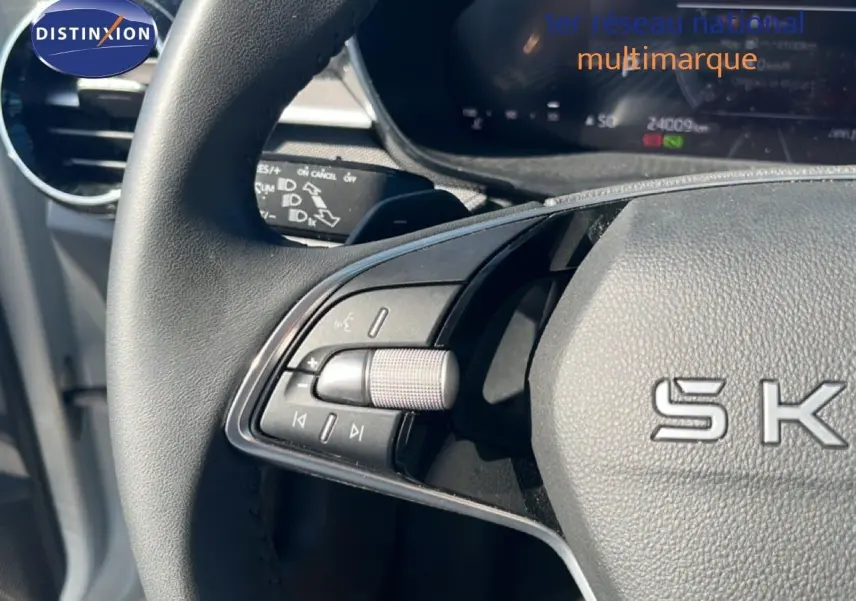Gros plan sur la partie gauche du volant noir de la Skoda Fabia 2025, avec commandes audio intégrées.