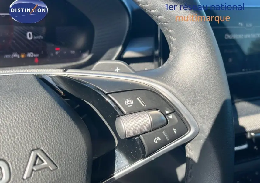 Gros plan sur les commandes au volant en cuir noir de la Skoda Fabia 2025, avec molette et boutons multifonctions.
