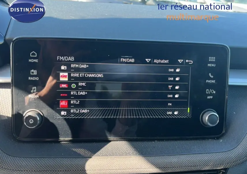 Écran tactile central de la Skoda Fabia 2025 en Reflex Silver, affichant les options radio FM/DAB dans l'habitacle.