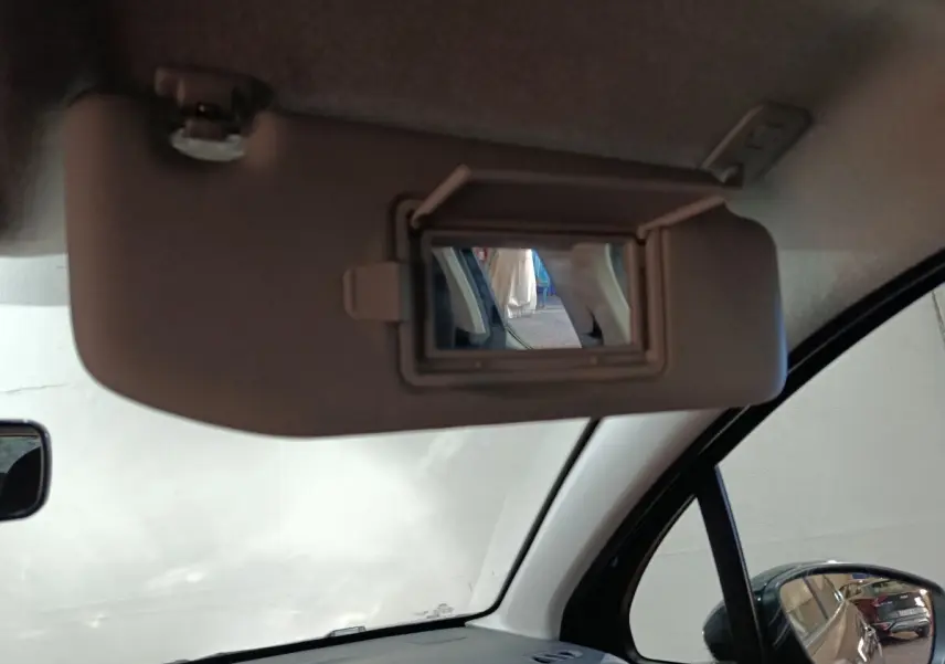 Miroir de courtoisie ouvert sur le pare-soleil côté conducteur à l'intérieur d'une Citroën C3 2024 gris foncé.