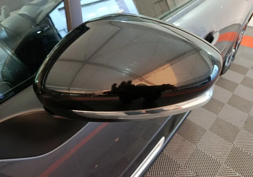 Rétroviseur droit noir brillant de la Citroën C3 gris foncé, vue rapprochée avec clignotant intégré.