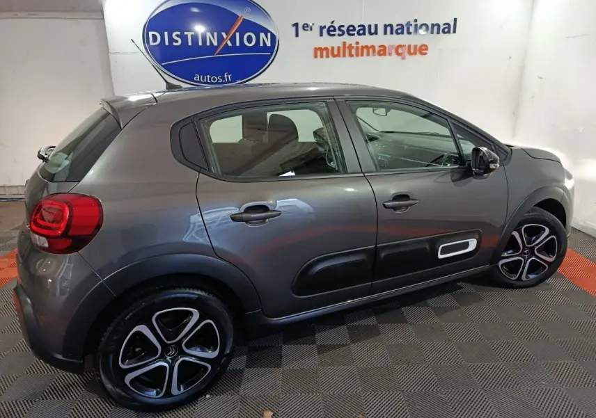 Vue latérale droite d'une Citroën C3 2024 gris foncé avec protections de porte noires et jantes bicolores.