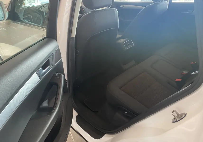 Vue intérieure côté gauche arrière de l'Audi Q5 blanc 2012, montrant les sièges arrière et la portière ouverte.