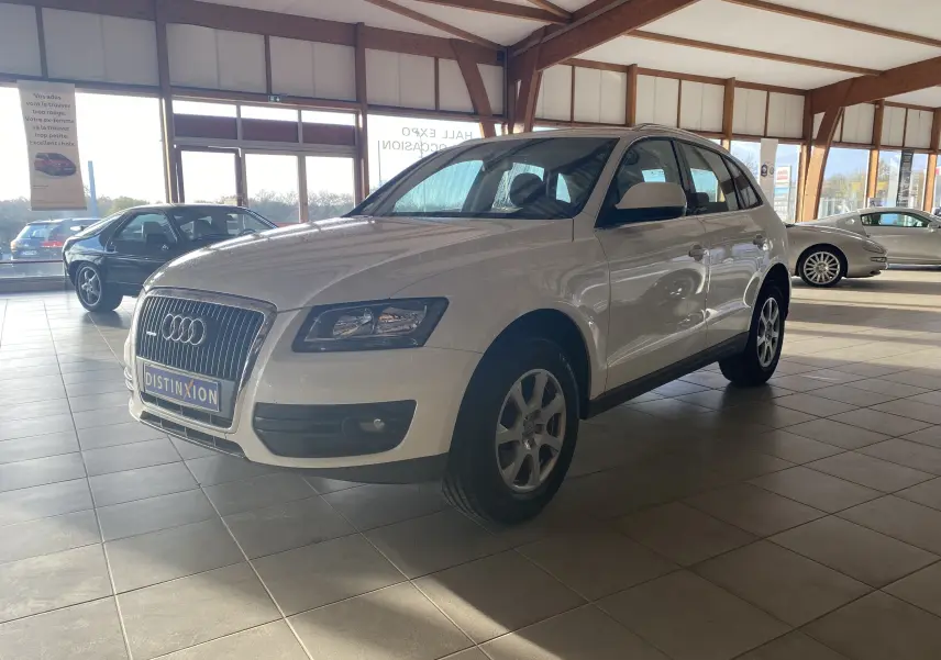 Audi Q5 blanc vue 3/4 avant droit dans un showroom lumineux avec jantes alliage et calandre chromée.