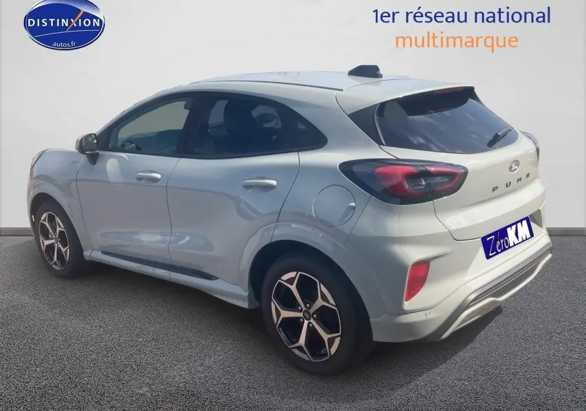 Ford Puma gris cactus vu en 3/4 arrière droit avec jantes 17 pouces et feux arrière LED distinctifs.