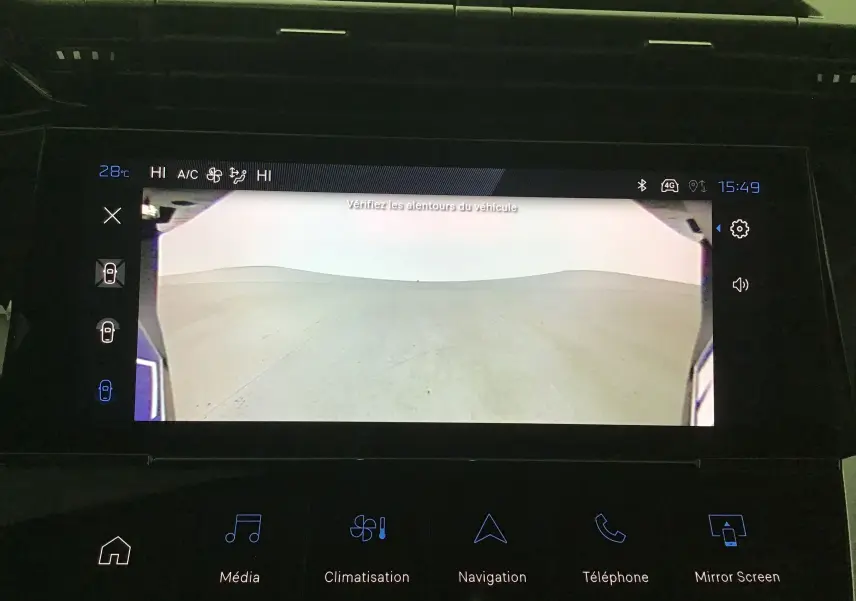 Vue de la caméra 360 du tableau de bord d'une Peugeot 308 gris Sellenium montrant l'environnement autour du véhicule.