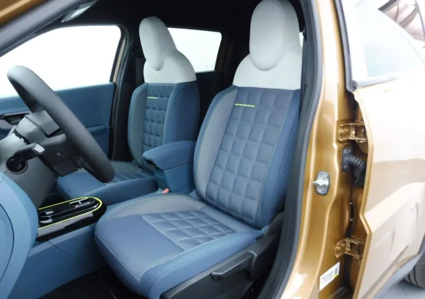 Vue intérieure côté conducteur de la FIAT Grande Panda 2025 en bronze luna, sièges bi-ton bleu et blanc avec surpiqûres.