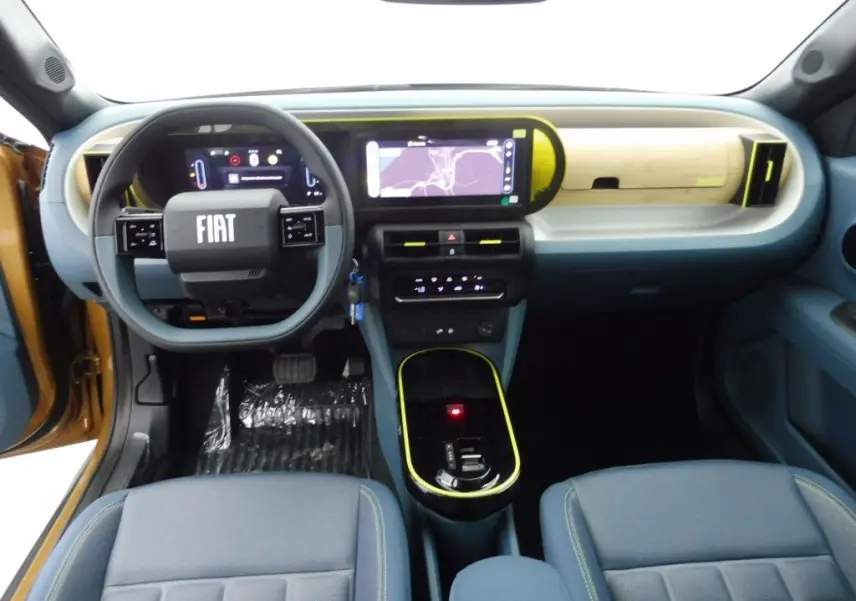 Vue intérieure avant de la Fiat Grande Panda bronze luna 2025, tableau de bord moderne avec écran tactile et volant multifonction.