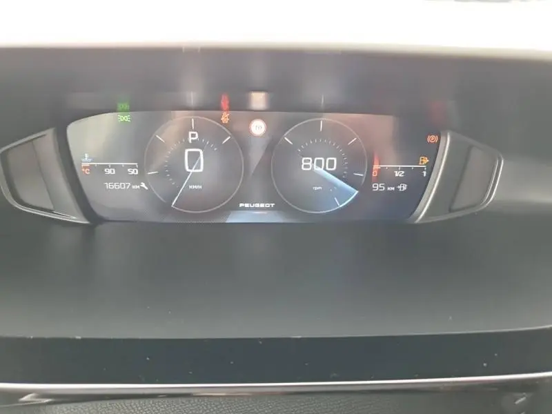 Tableau de bord numérique de Peugeot 308 2024 affichant vitesse, compte-tours et jauges, vue frontale rapprochée.