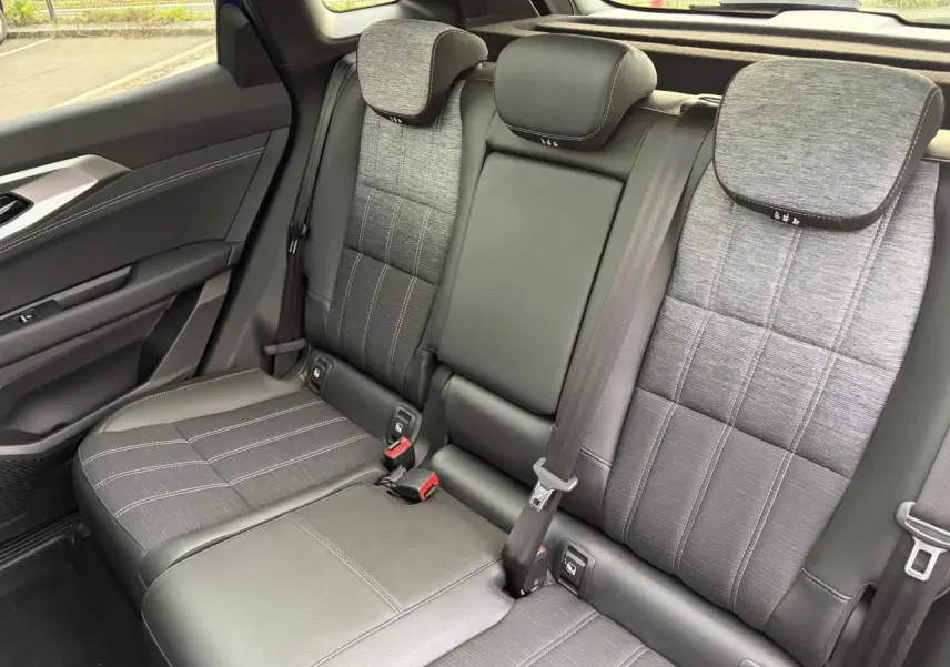 Vue côté droit de la banquette arrière grise mixte tissu et cuir du Renault Austral E-Tech 2025 avec appuie-têtes et ceintures visibles.