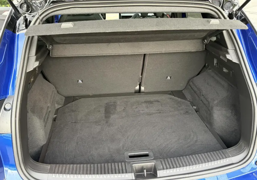 Coffre ouvert du Renault Austral E-Tech bleu Iron, vue plongeante montrant l'espace de rangement intérieur.