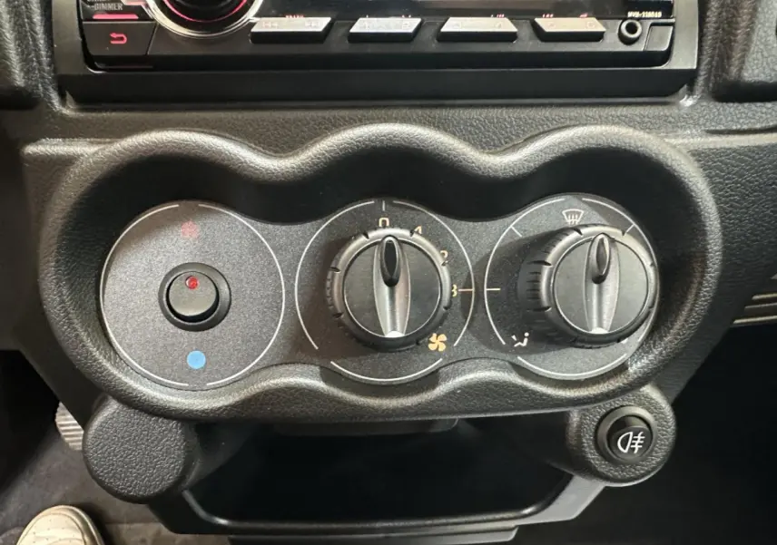 Gros plan sur les commandes de climatisation noires de l'Aixam Minauto E Access 2026, avec boutons rotatifs et bouton antibrouillard.