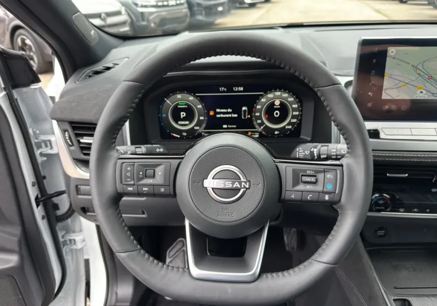 Vue intérieure centrée sur le volant cuir multifonctions d’un Nissan Qashqai E-POWER 205 Tekna Plus blanc lunaire.