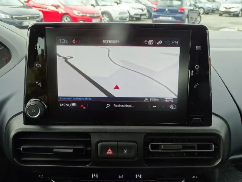 Écran tactile du système de navigation du Peugeot Rifter gris Artense, vue intérieure centrée sur le tableau de bord.