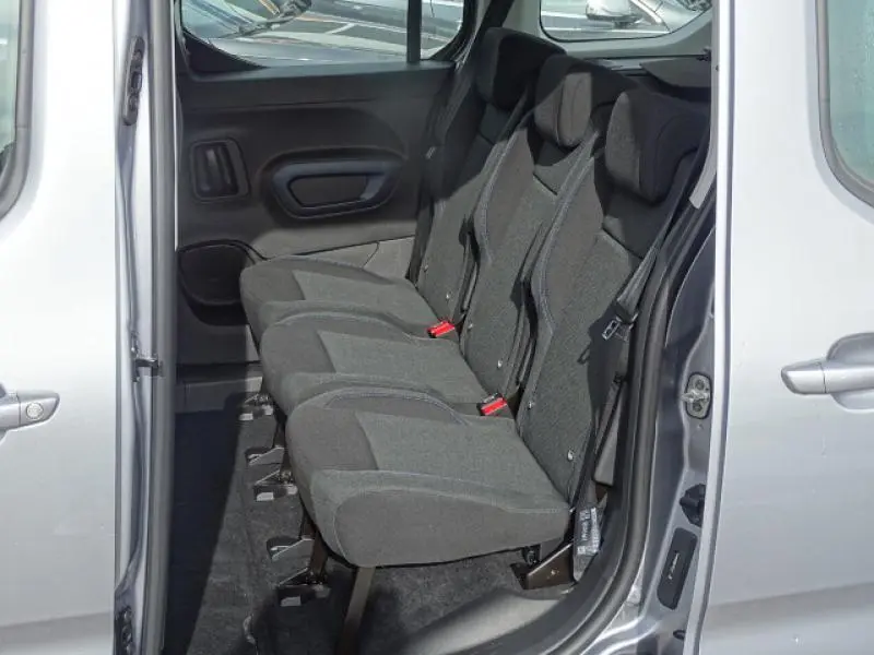Vue intérieure côté gauche sur la banquette arrière grise du Peugeot Rifter 2019 avec porte coulissante ouverte.