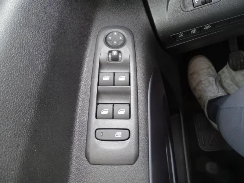 Vue rapprochée des commandes des lève-vitres et rétroviseurs sur la porte conducteur du Peugeot Rifter gris Artense 2019.