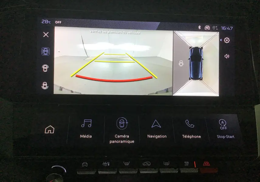 Affichage de la caméra 360 de la Peugeot 308 blanche, vue arrière avec lignes de guidage pour le stationnement.