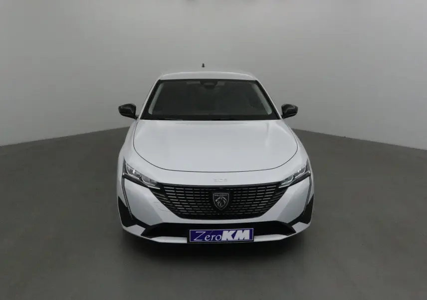 Peugeot 308 blanc Okenite vue de face, mettant en valeur sa calandre noire et ses phares LED fins.