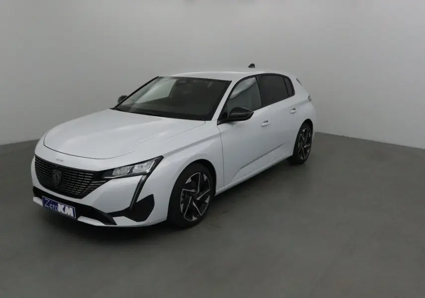 Peugeot 308 blanc Okenite vue 3/4 avant droit dans un studio, avec jantes alliage et calandre noire distinctive.
